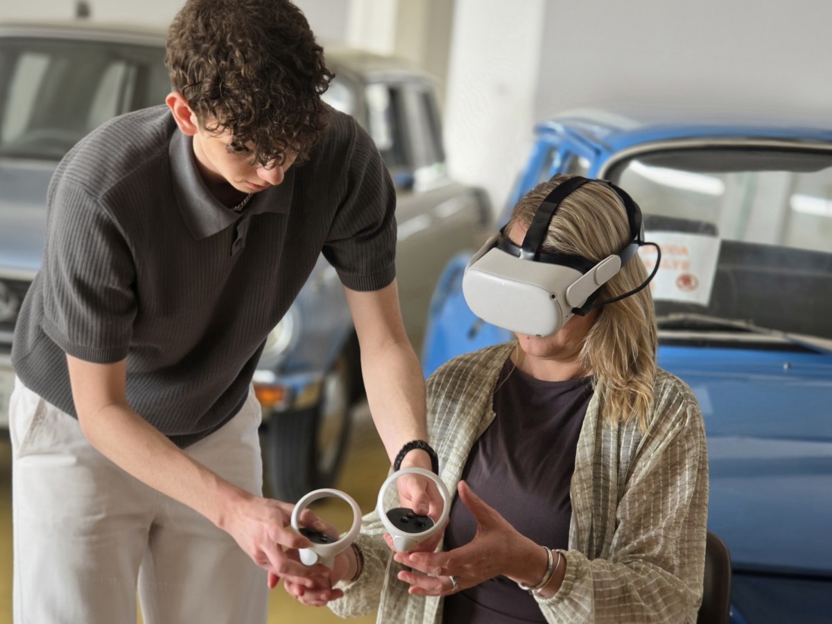 Člen týmu ukazuje hostovi, jak ovládat VR headset